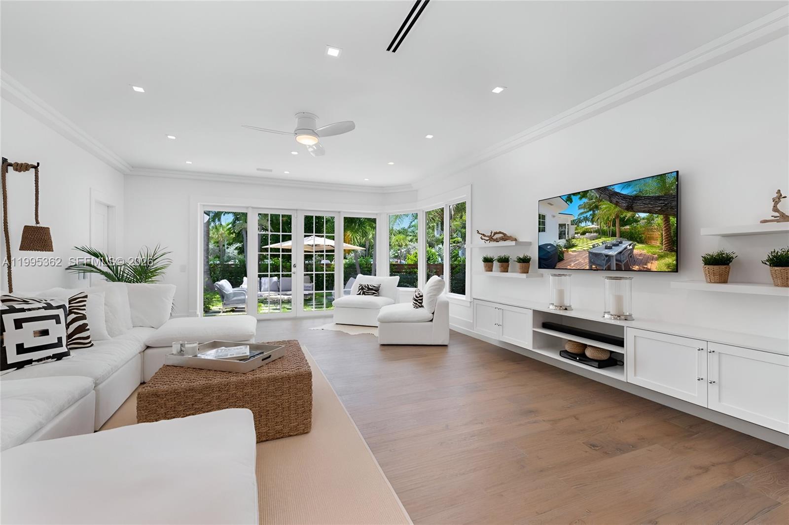 2575 Pine Tree Drive Miami Beach, FL 33140 - Photo 3 of 32 a living room with furniture and a flat screen tv