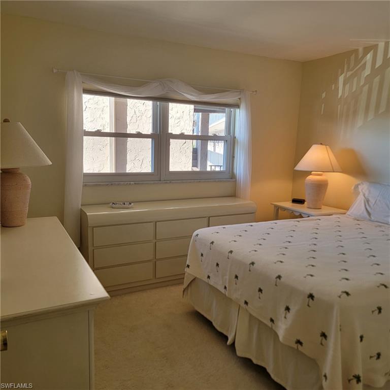 5483 Rattlesnake Hammock Road, Unit B201 Naples, FL 34113 - Photo 16 of 22 a bedroom with a bed and a window