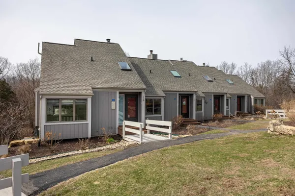 a view of a house with a yard and wooden fence