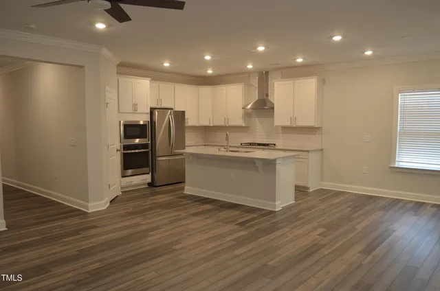 a kitchen with stainless steel appliances a refrigerator and a stove top oven