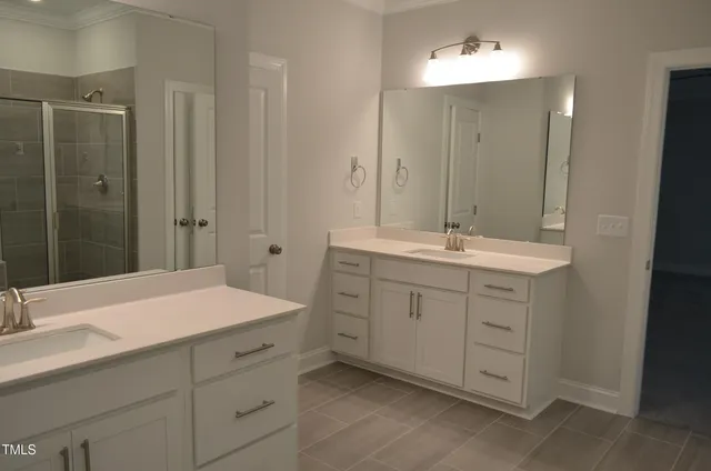 a bathroom with a sink shower and a mirror