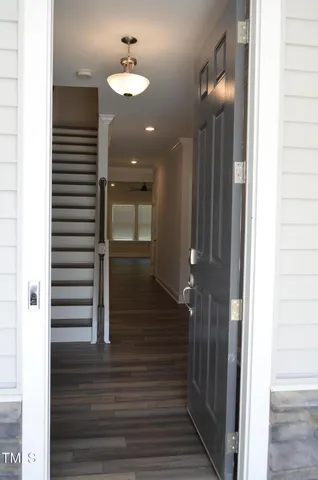a view of a hallway with wooden floor and staircase