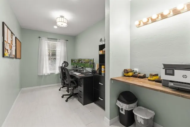 a view of a workspace with furniture and a window