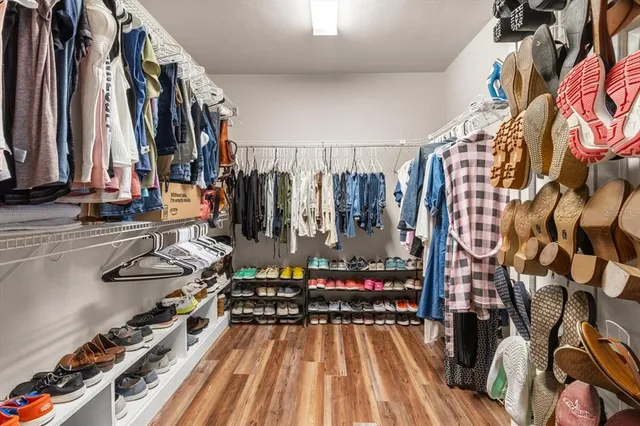 a view of walk in closet with clothes and shoes