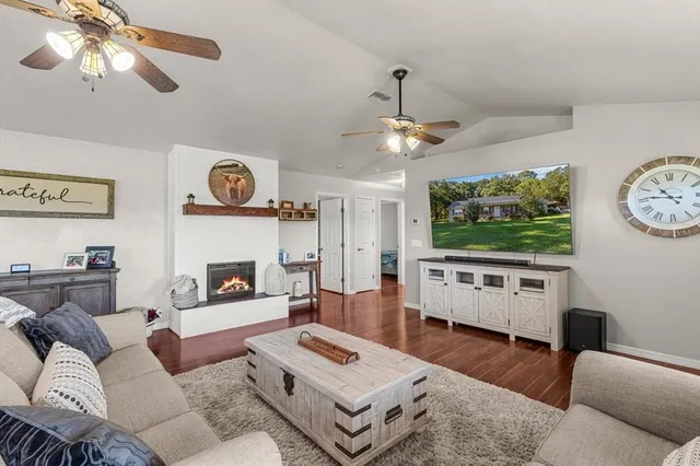a living room with furniture a flat screen tv and a wall clock
