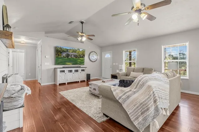 a living room with furniture a chandelier and a flat screen tv