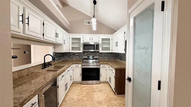 a kitchen with stainless steel appliances granite countertop a stove a sink dishwasher and a refrigerator