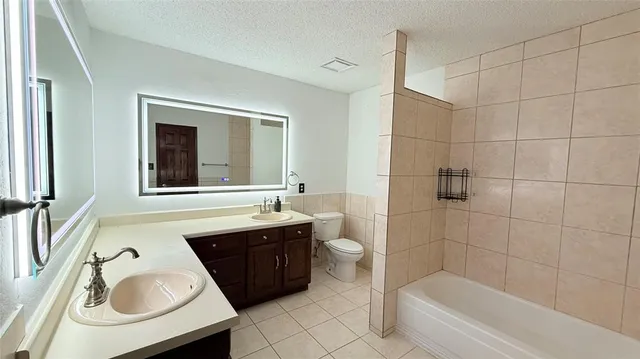 a bathroom with a tub sink and mirror