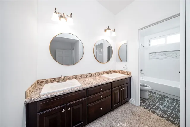 a bathroom with a granite countertop sink a toilet and a mirror