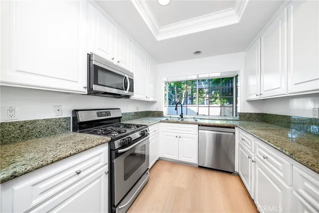 a kitchen with stainless steel appliances granite countertop a stove sink and microwave