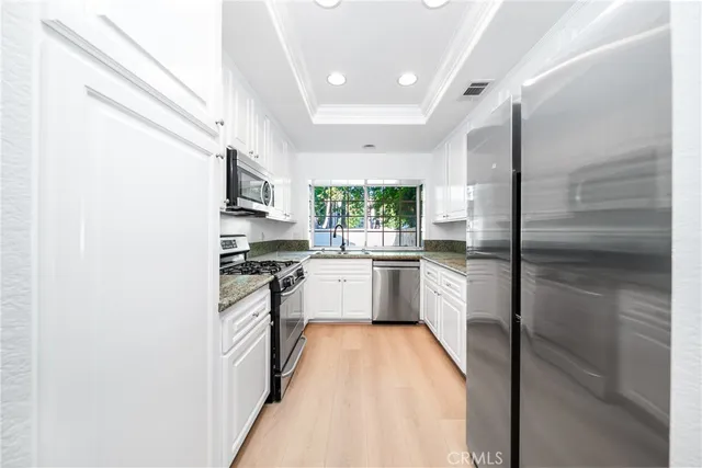 a kitchen with stainless steel appliances a refrigerator sink and stove