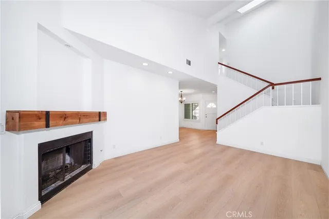 a view of empty room with wooden floor and fireplace