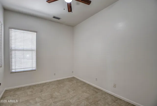 an empty room with a window and a ceiling fan