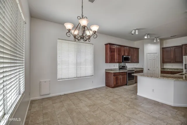 a view of kitchen with refrigerator stove microwave and cabinets
