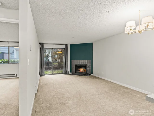 an empty room with floor to ceiling window and fireplace