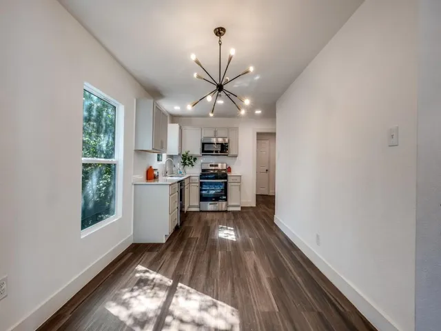 a kitchen with stainless steel appliances granite countertop a sink stove and wooden floors