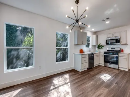 a kitchen with granite countertop stainless steel appliances a stove top oven a sink a counter space and cabinets