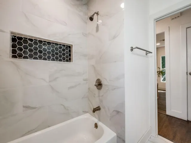 a bathroom with a sink a toilet a mirror and shower