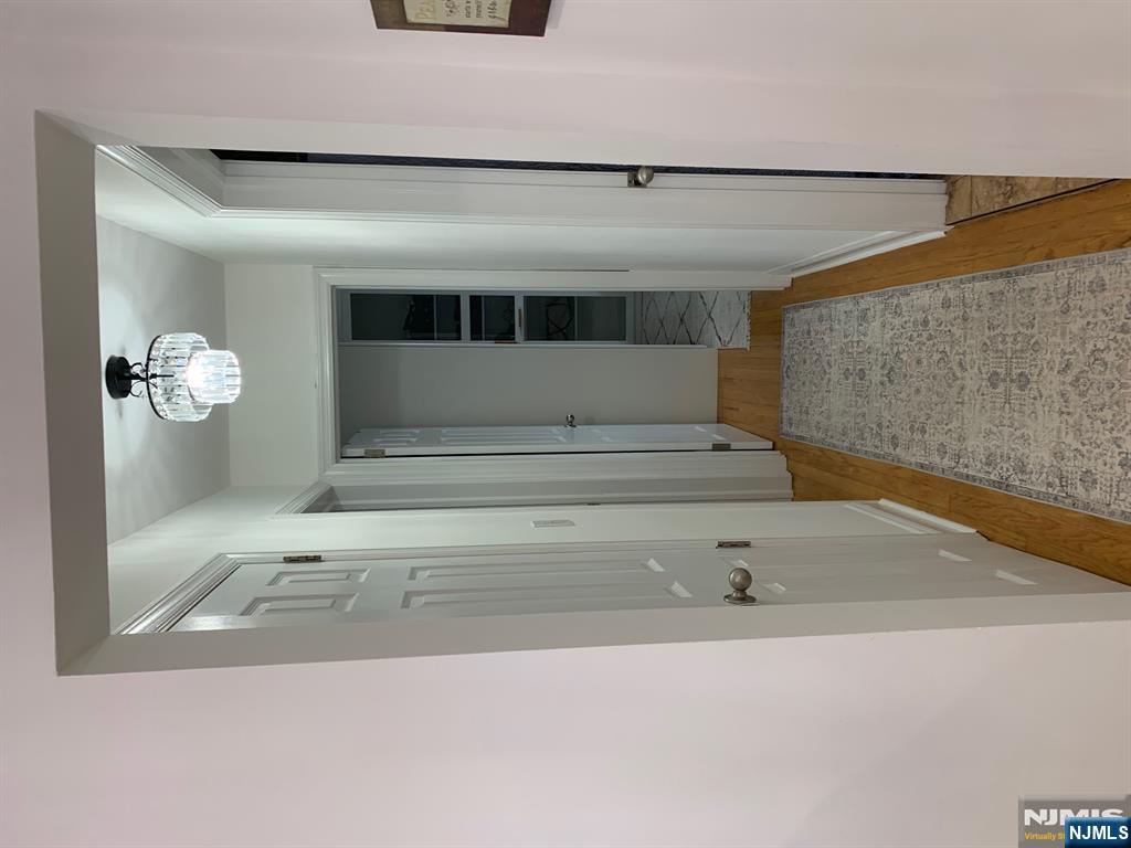 272 Wilson Avenue Fairview, NJ 07022 - Photo 11 of 15 a view of a hallway with wooden floor and a bathroom