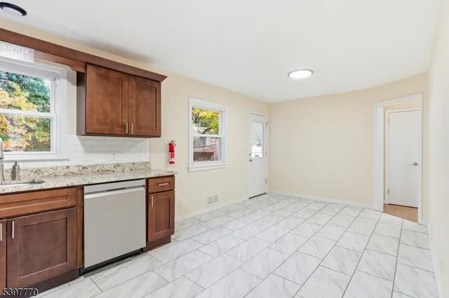 a kitchen with stainless steel appliances granite countertop a sink and a stove top oven