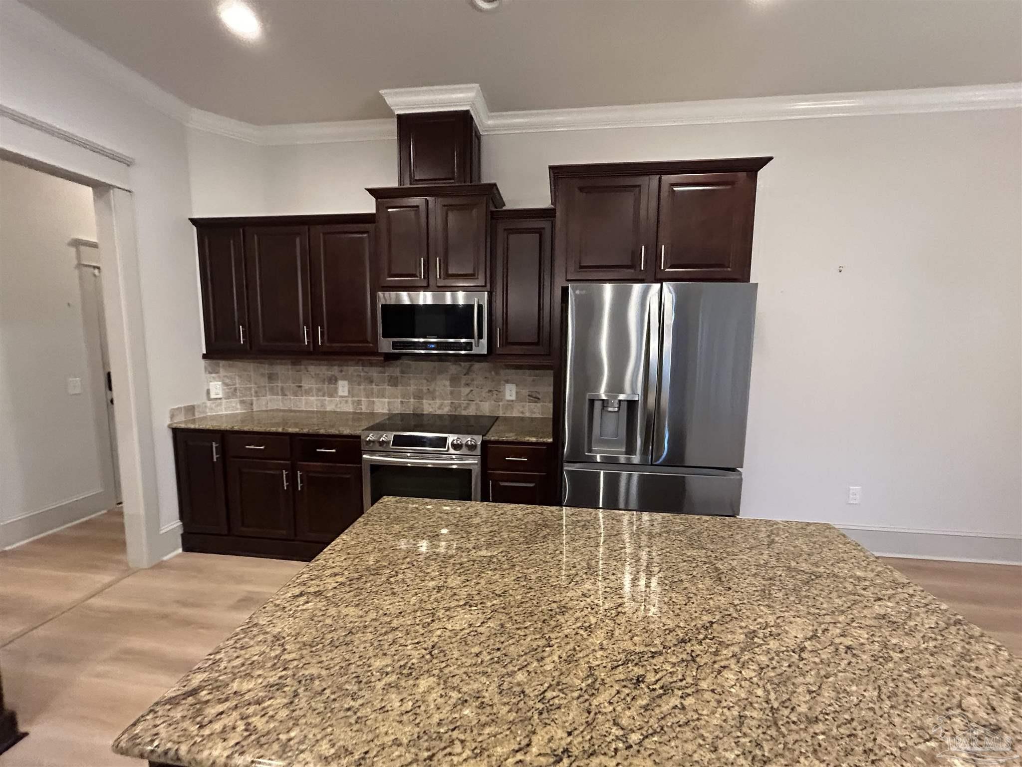 4081 Manchester Court Pace, FL 32571 - Photo 17 of 34 a kitchen with stainless steel appliances granite countertop a refrigerator and a stove top oven