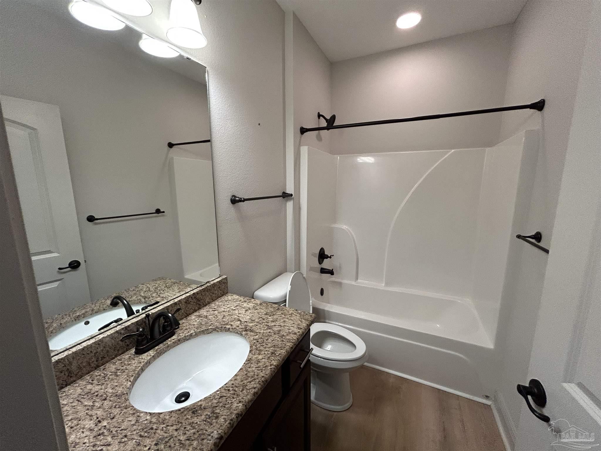 4081 Manchester Court Pace, FL 32571 - Photo 10 of 34 a bathroom with a granite countertop sink a mirror and a bathtub