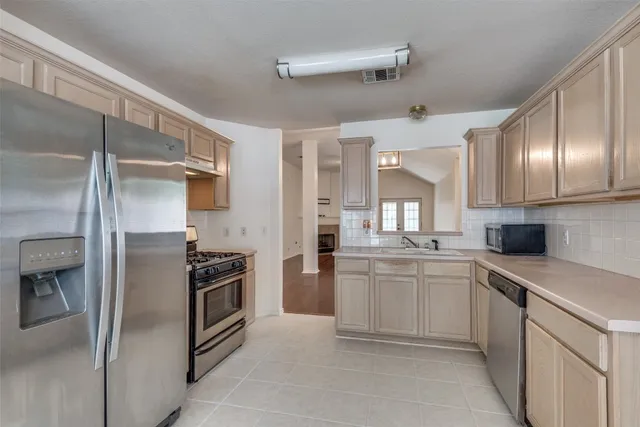 a kitchen with a sink stainless steel appliances and cabinets