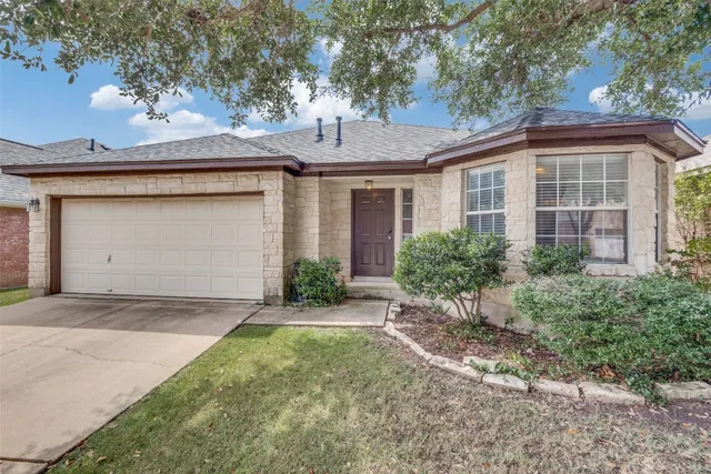 a front view of a house with a garden and plants