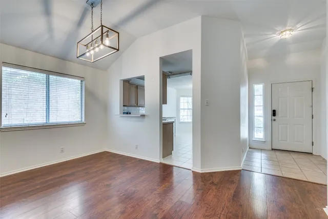 a view of empty room with wooden floor and window