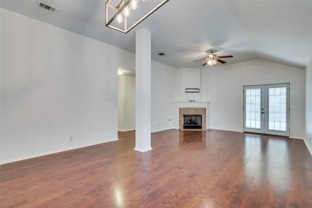 a view of an empty room with a fireplace and a window