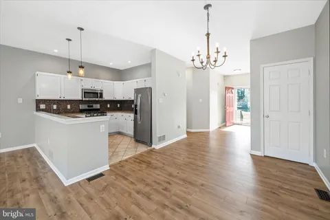 a kitchen with granite countertop a stove a sink a refrigerator and a stove
