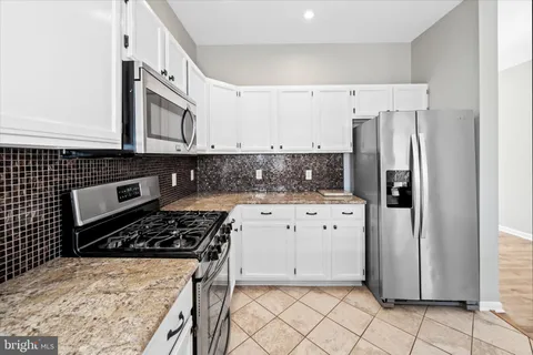 a kitchen with a stove a refrigerator and cabinets