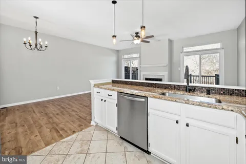 a view of a kitchen with a sink dishwasher a fireplace with wooden floor