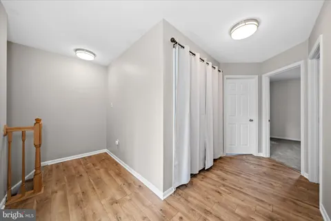 a view of a room with wooden floor and a window