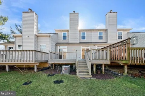 a view of a house with a deck and a yard