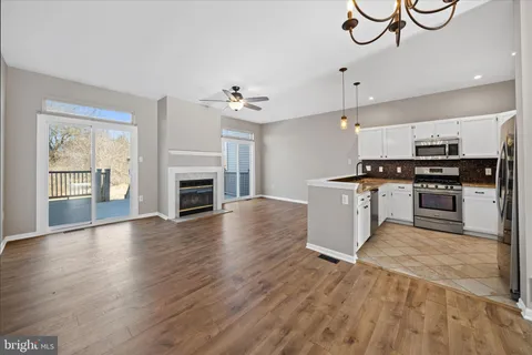 a view of kitchen with granite countertop stove top oven and cabinets