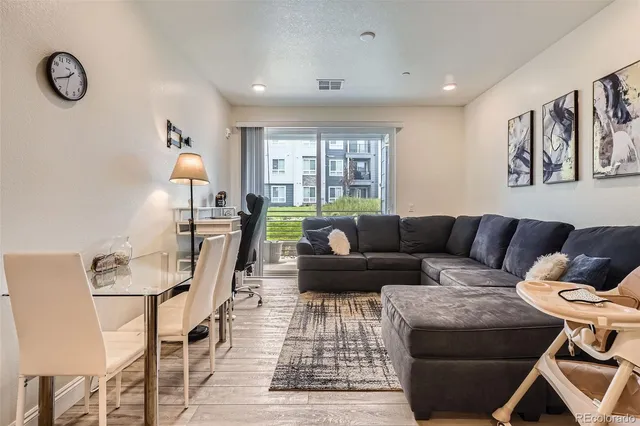 a living room with furniture a rug and a window