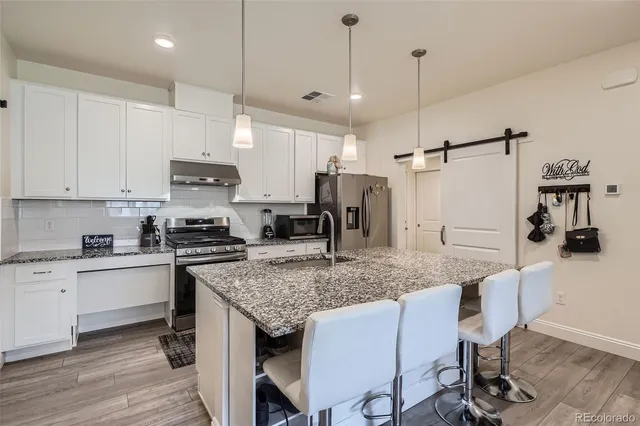 a kitchen with stainless steel appliances granite countertop a sink stove and refrigerator