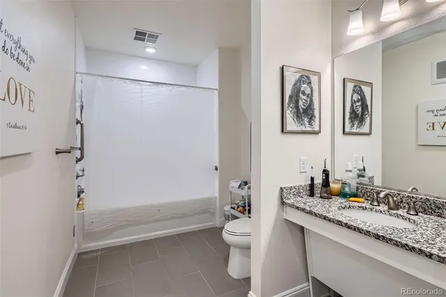 a bathroom with a granite countertop sink toilet and shower