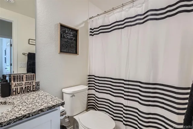 a bathroom with a granite countertop sink toilet and shower