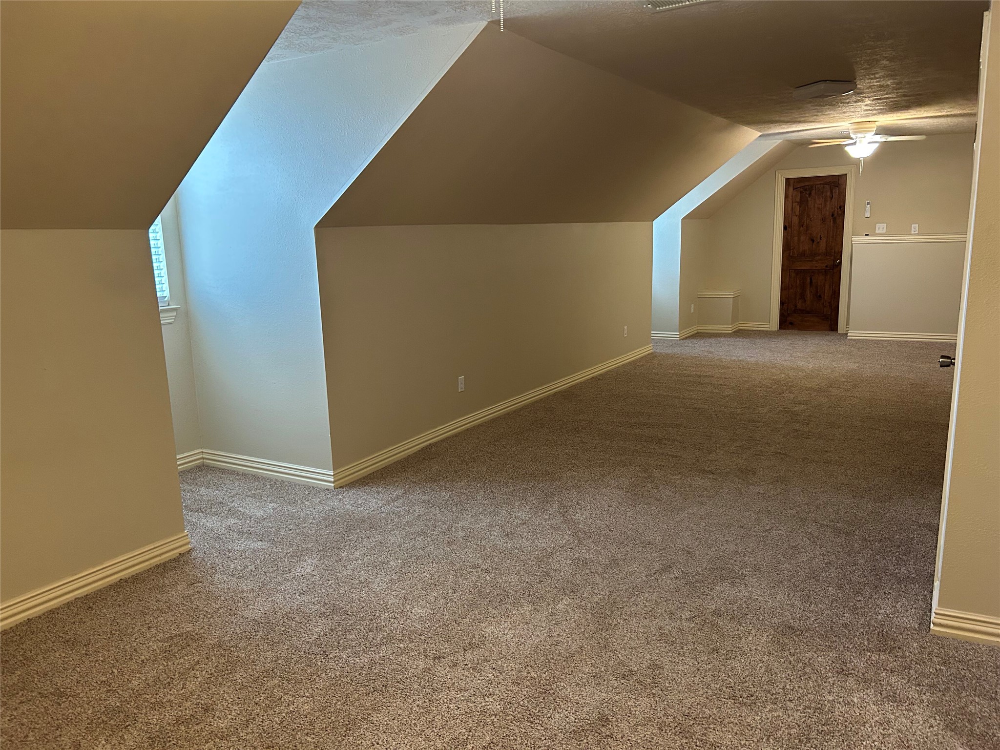 329 Flash Circle Luling, TX 78648 - Photo 25 of 32 Angled ceilings and soft carpeting define this spacious bonus room.