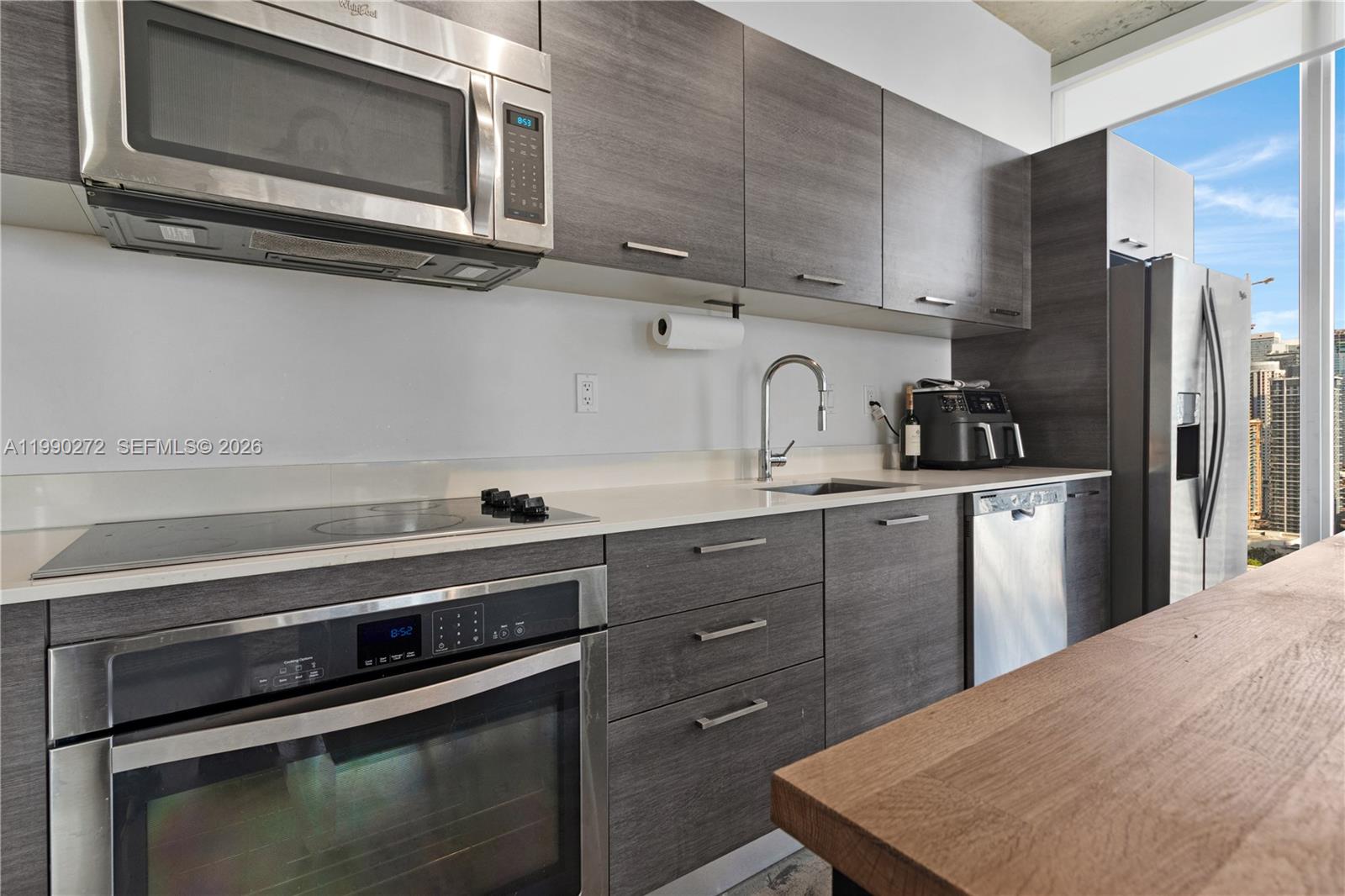 151 Southeast 1st Street, Unit 2802 Miami, FL 33131 - Photo 13 of 31 a kitchen with a stove microwave and sink