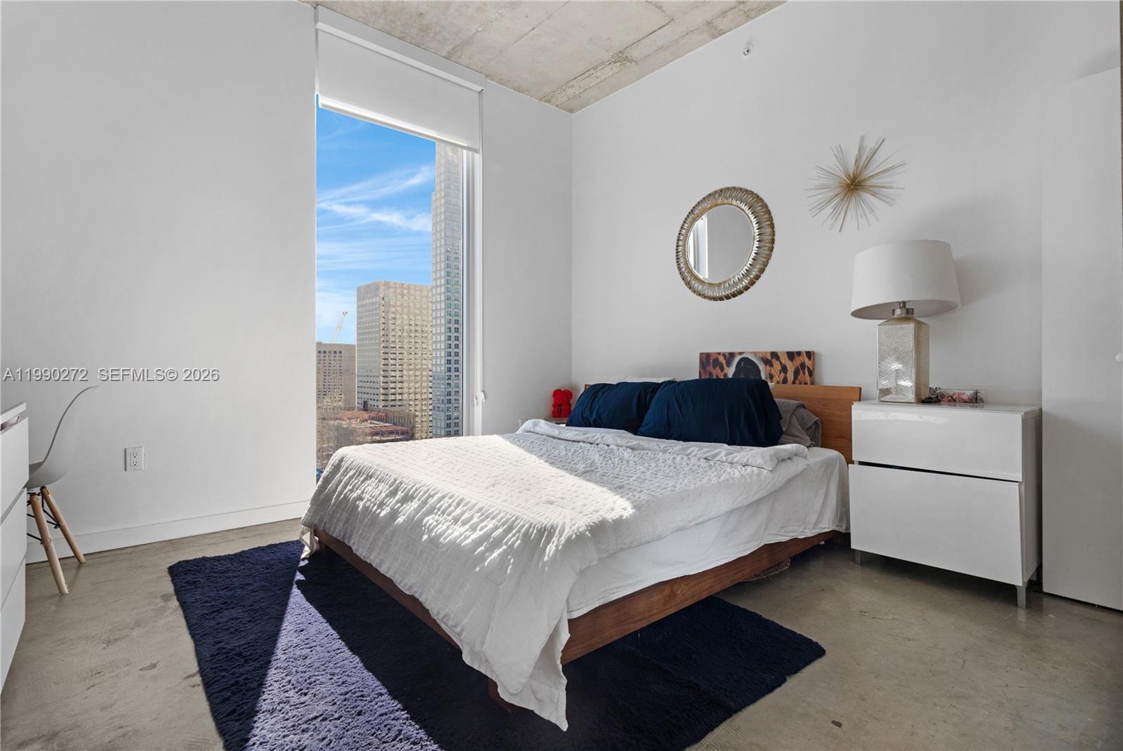 151 Southeast 1st Street, Unit 2802 Miami, FL 33131 - Photo 18 of 31 a bed room with a bed and a lamp