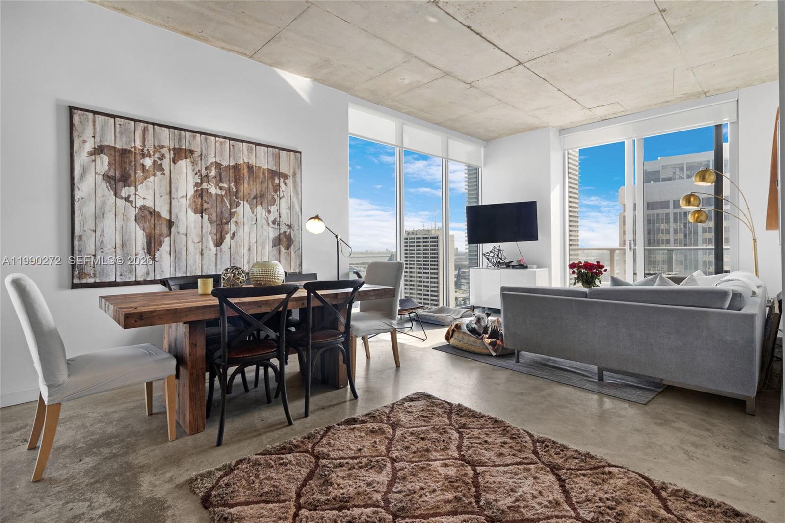 151 Southeast 1st Street, Unit 2802 Miami, FL 33131 - Photo 7 of 31 a living room with furniture a rug and a large window