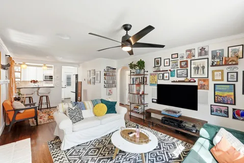 a living room with furniture and a flat screen tv with a bookshelf