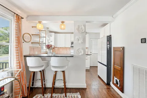 a kitchen with stainless steel appliances a dining table chairs and refrigerator
