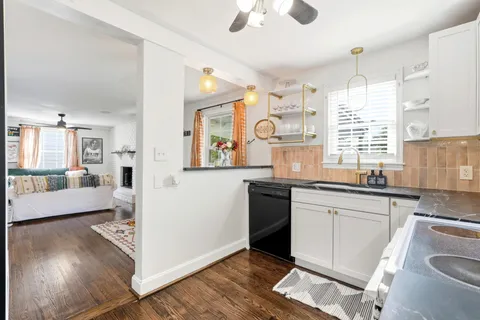 a kitchen with granite countertop a stove a sink and a refrigerator