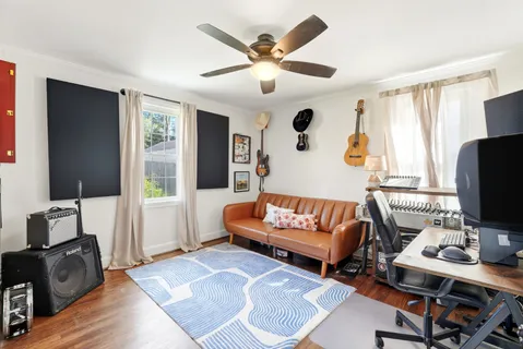 a living room with furniture ceiling fan and a window