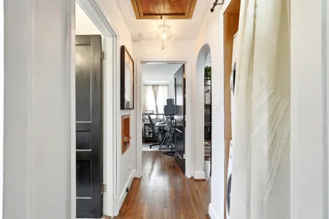a view of hallway with livingroom and wooden floor
