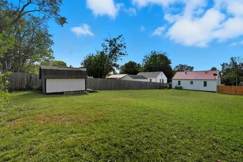 a backyard of a house with plants and tree